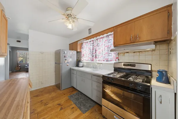 a kitchen with stainless steel appliances white cabinets and a stove top oven