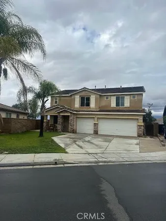 a front view of a house with a garden and yard