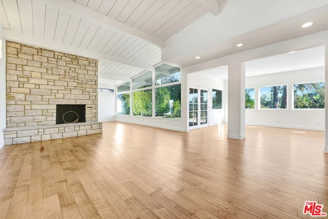 an empty room with wooden floor and fireplace
