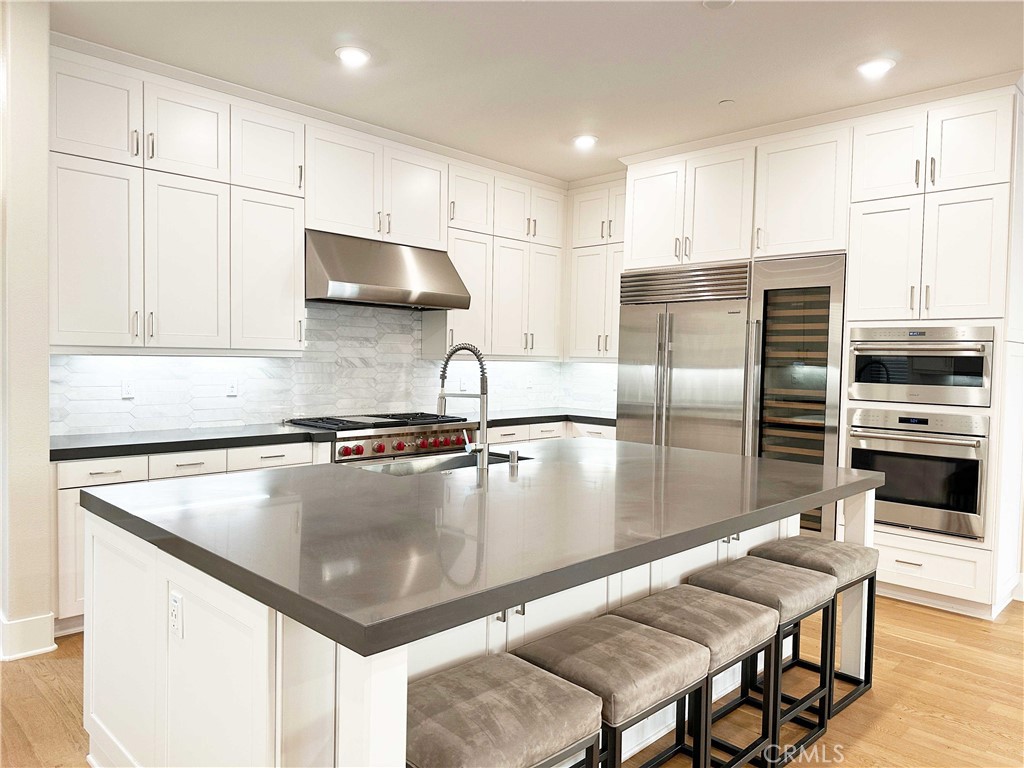 58 Ray Irvine, CA 92618 - Photo 8 of 35 a kitchen with stainless steel appliances granite countertop a stove a sink a microwave a refrigerator and white cabinets