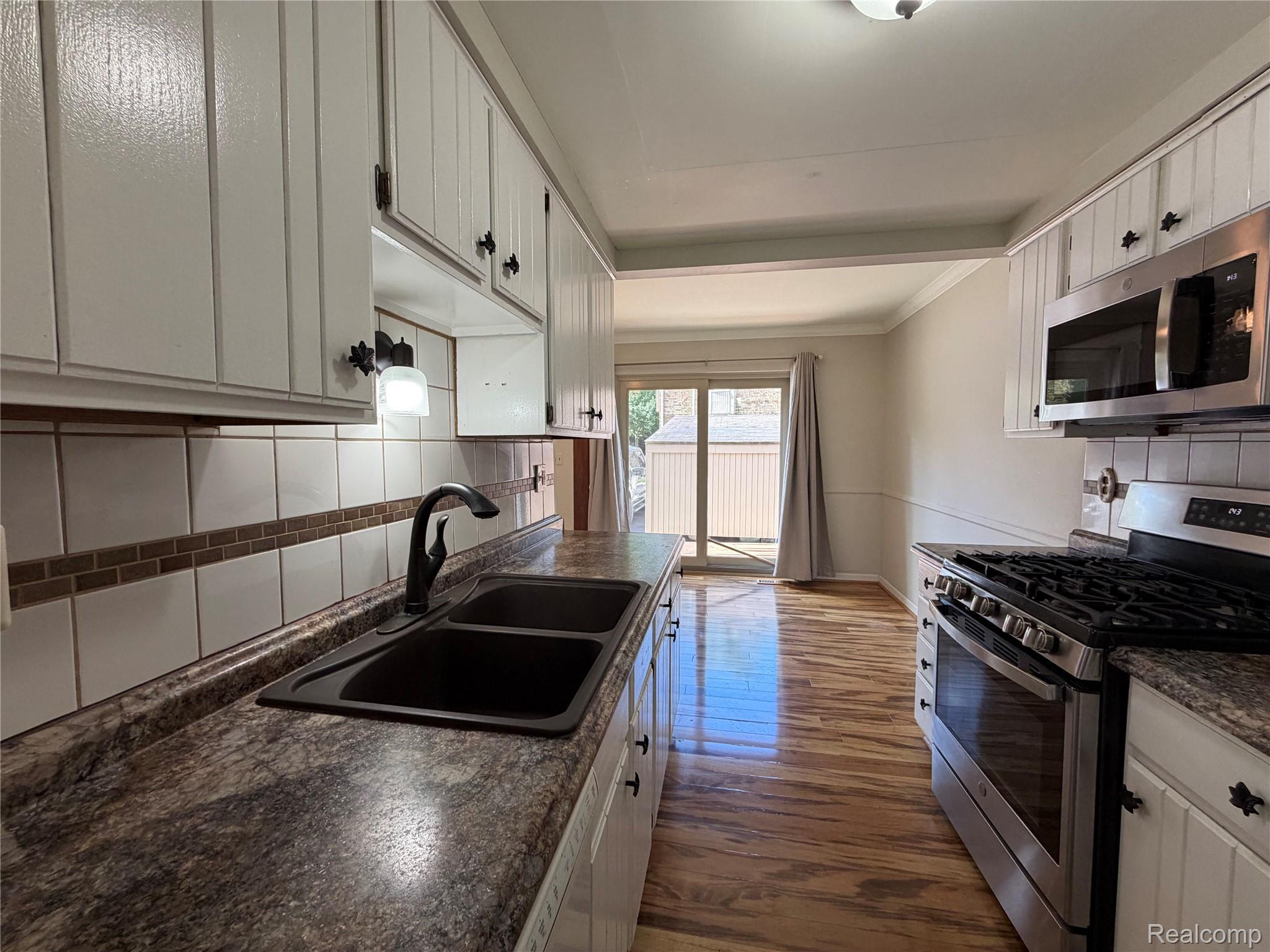 629 Oakbrook West, Unit 18 Rochester, MI 48307 - Photo 10 of 22 Kitchen featuring white cabinetry, a double basin sink with a matte black faucet, and stainless steel appliances