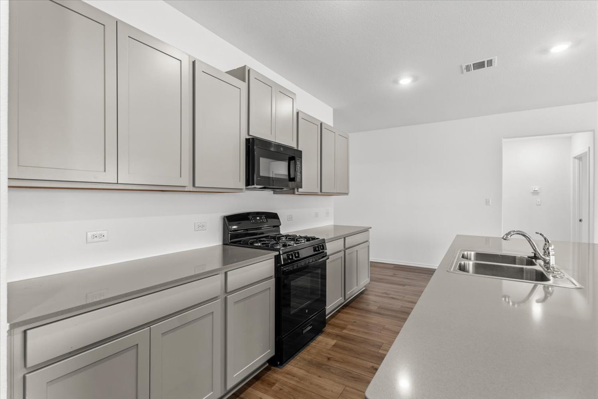 167 Jeffers Kyle, TX 78640 - Photo 38 of 40 Kitchen with black appliances, gray cabinetry, dark wood-type flooring, and recessed lighting