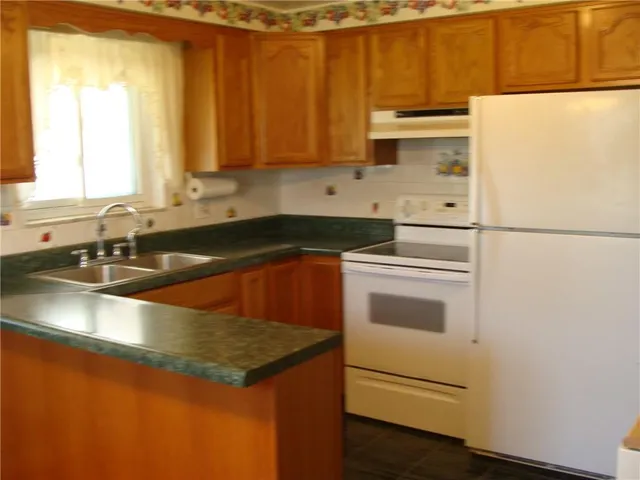 a kitchen with granite countertop white cabinets and white appliances