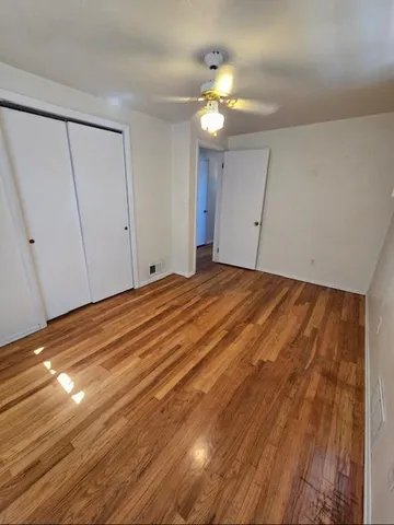 a view of an empty room with a chandelier fan