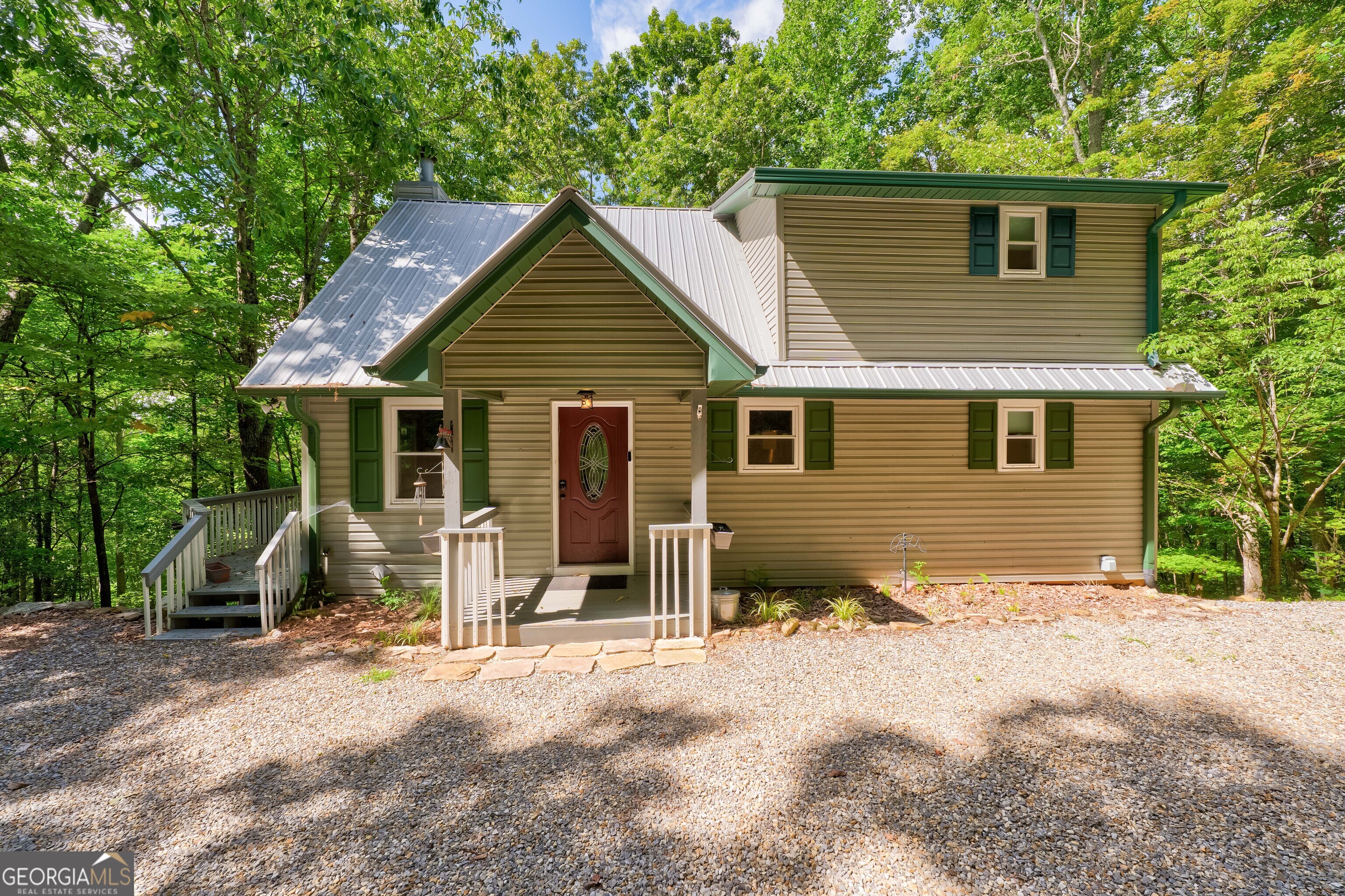 a view of a house with a yard and chairs
