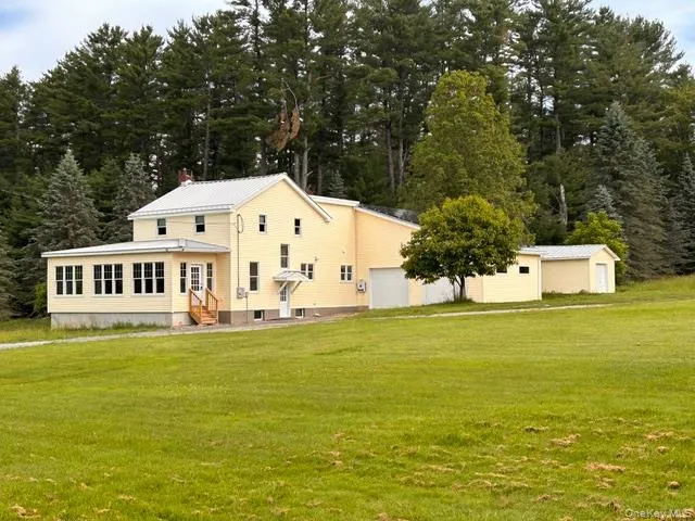 a view of a house with a big yard and large trees