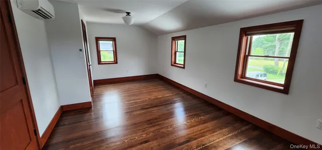 a view of a room with wooden floor and window