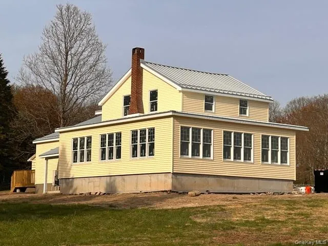 a view of a large building next to a yard with big trees