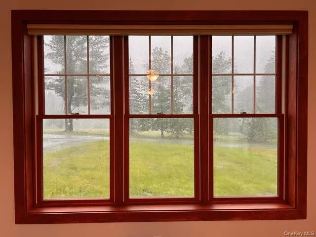 a view of a house with backyard and trees