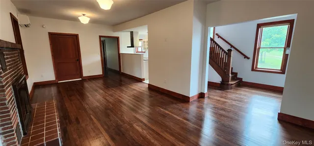a view of an entryway with wooden floor and door