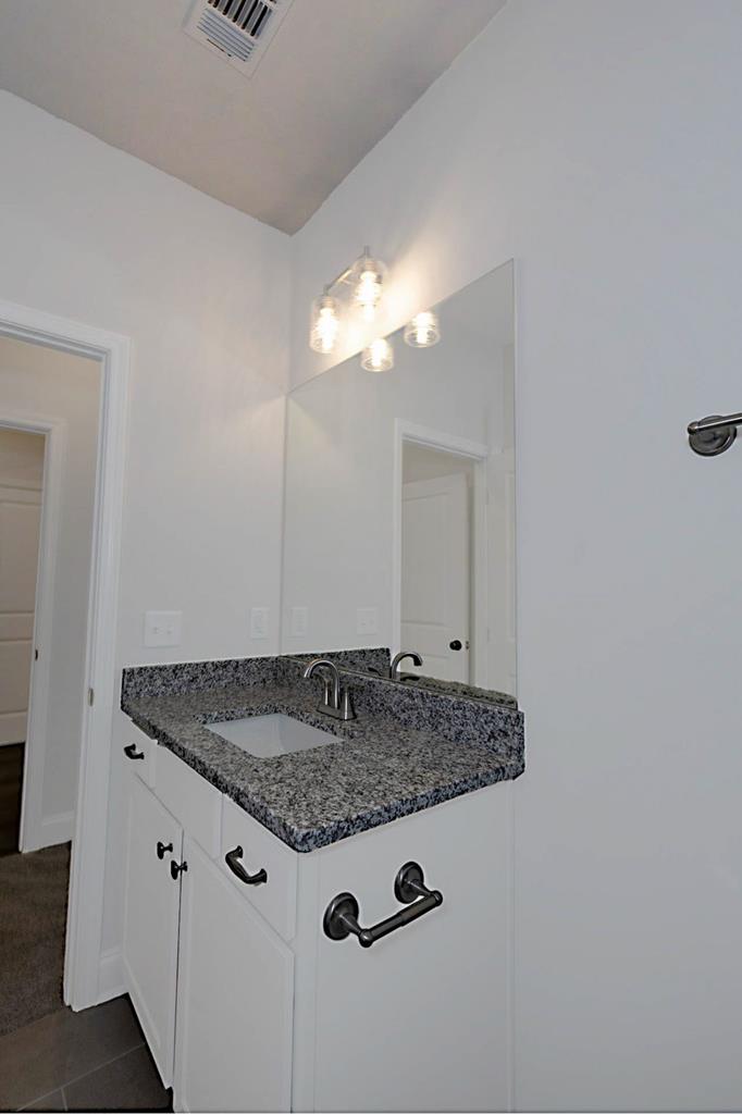 8705 McKee Road Upatoi, GA 31829 - Photo 18 of 42 a bathroom with a granite countertop sink and mirror