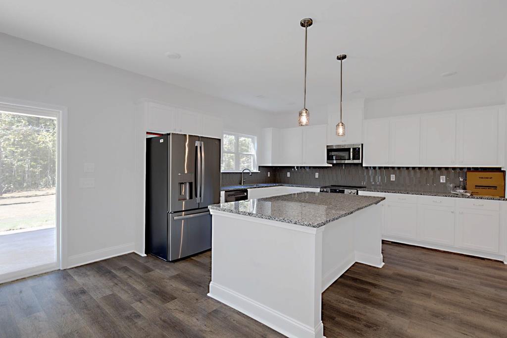 8705 McKee Road Upatoi, GA 31829 - Photo 6 of 42 a kitchen with kitchen island a counter top a stove a refrigerator and a sink