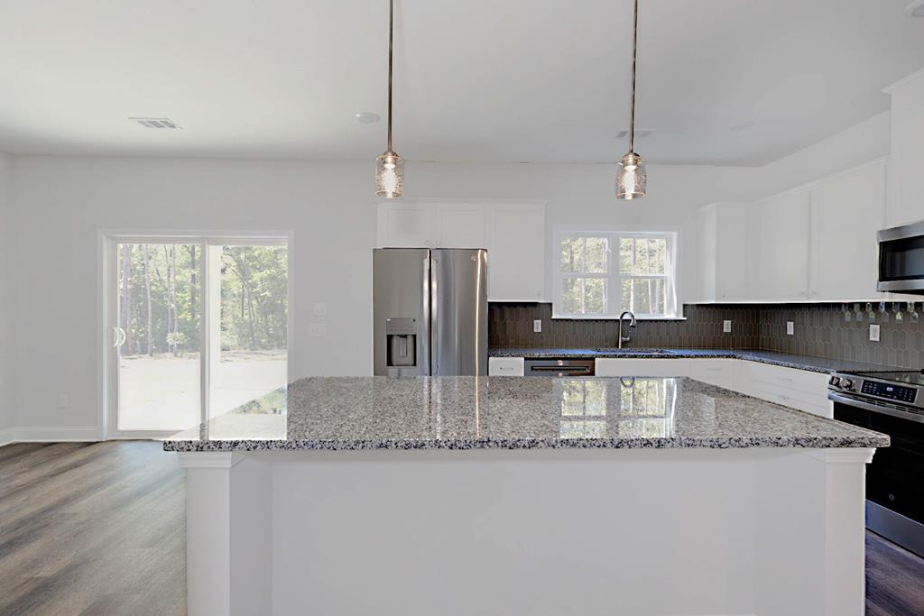 8705 McKee Road Upatoi, GA 31829 - Photo 7 of 42 a large kitchen with stainless steel appliances granite countertop a sink a stove and a refrigerator