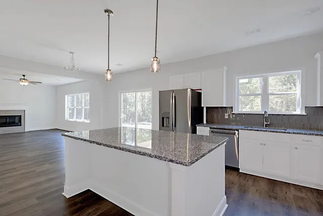 a kitchen with stainless steel appliances granite countertop a sink stove microwave and refrigerator