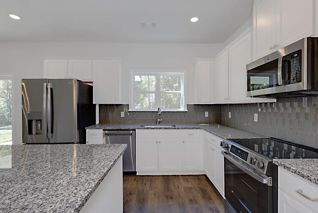 8705 McKee Road Upatoi, GA 31829 - Photo 9 of 42 a kitchen with stainless steel appliances granite countertop a sink stove microwave and refrigerator