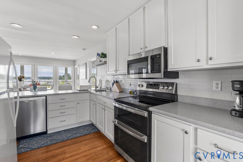 2082 Ocran Road White Stone, VA 22578 - Photo 18 of 50 a kitchen with granite countertop white cabinets and appliances
