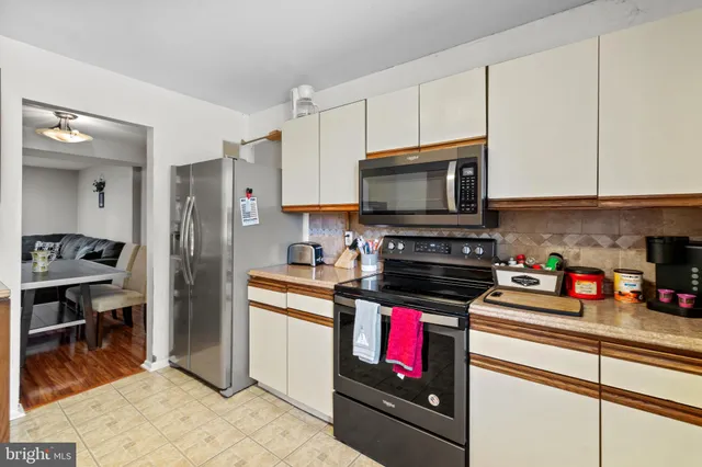 a kitchen with stainless steel appliances a stove a sink dishwasher a microwave oven with cabinets and wooden floor