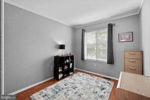 a view of a bedroom with baby bed and window