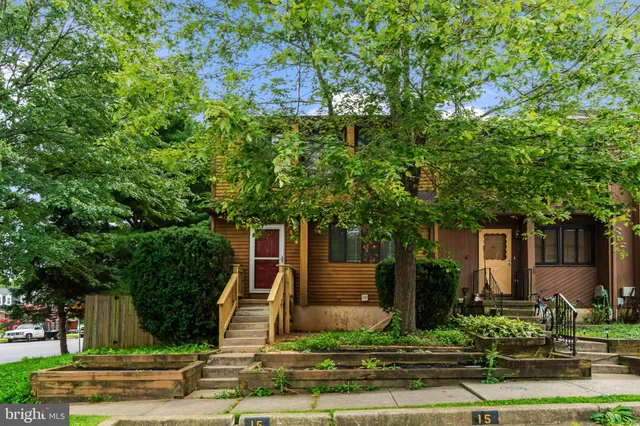 a front view of a house with a tree