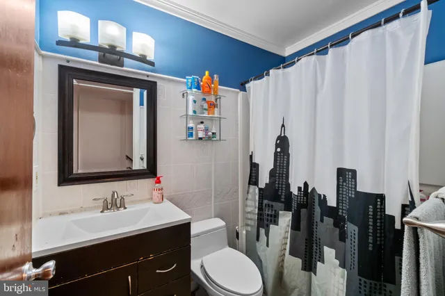 a bathroom with a sink vanity mirror and toilet