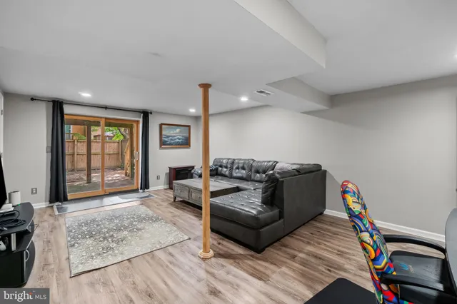 a living room with furniture a flat screen tv and a window