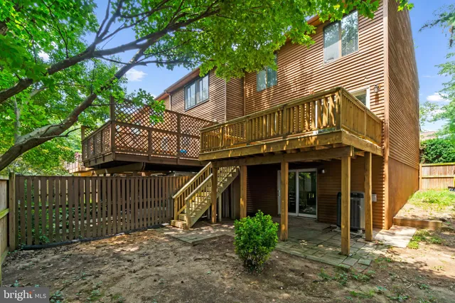 a view of a house with a small yard and wooden fence