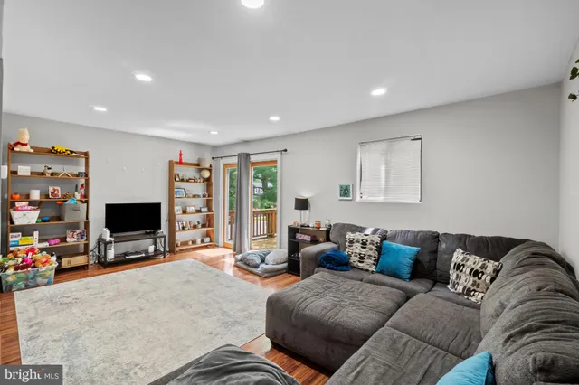 a living room with furniture a flat screen tv and a window