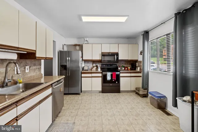 a kitchen with stainless steel appliances a refrigerator sink and microwave