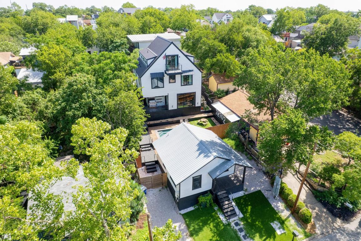 an aerial view of a house with a yard and large trees