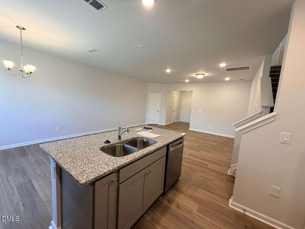5024 Reader Way Durham, NC 27703 - Photo 10 of 26 a kitchen with kitchen island granite countertop a sink and refrigerator