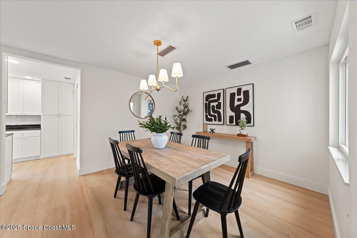 720 Wing Foot Lane Melbourne, FL 32940 - Photo 11 of 45 a view of a dining room with furniture and wooden floor