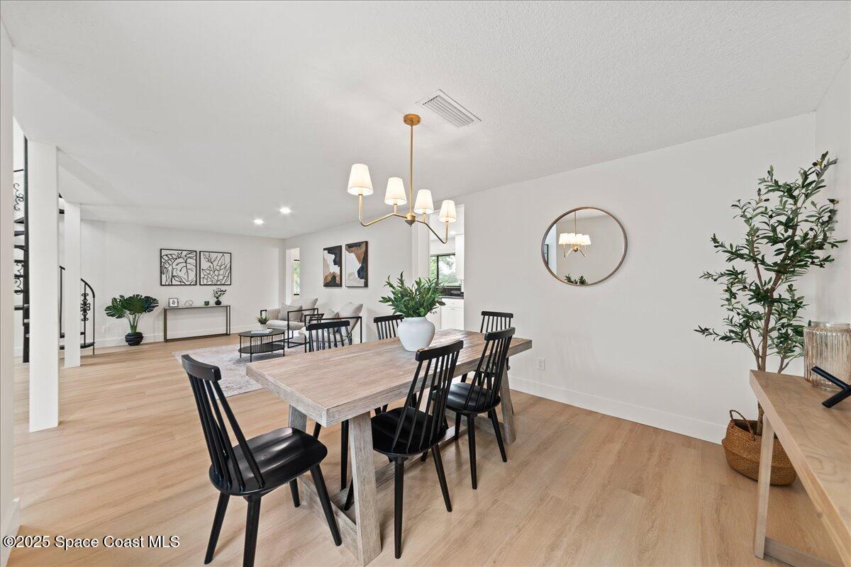 720 Wing Foot Lane Melbourne, FL 32940 - Photo 12 of 45 a view of a dining room and livingroom with furniture wooden floor a rug and a chandelier