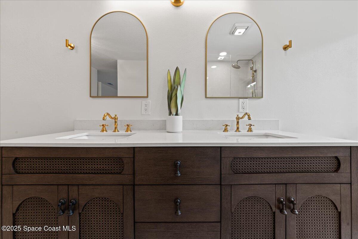 720 Wing Foot Lane Melbourne, FL 32940 - Photo 31 of 45 a bathroom with a sink and two mirror