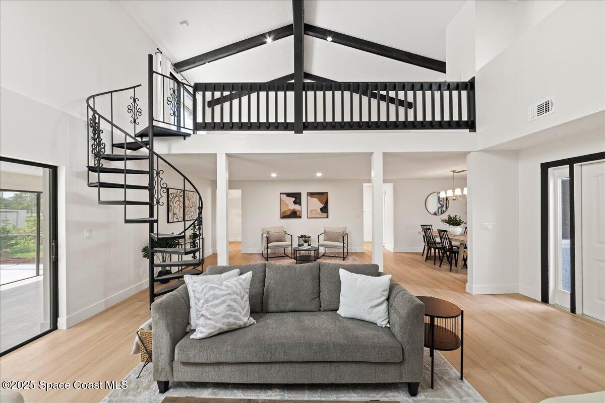 720 Wing Foot Lane Melbourne, FL 32940 - Photo 5 of 45 a living room with furniture stairs and a chandelier