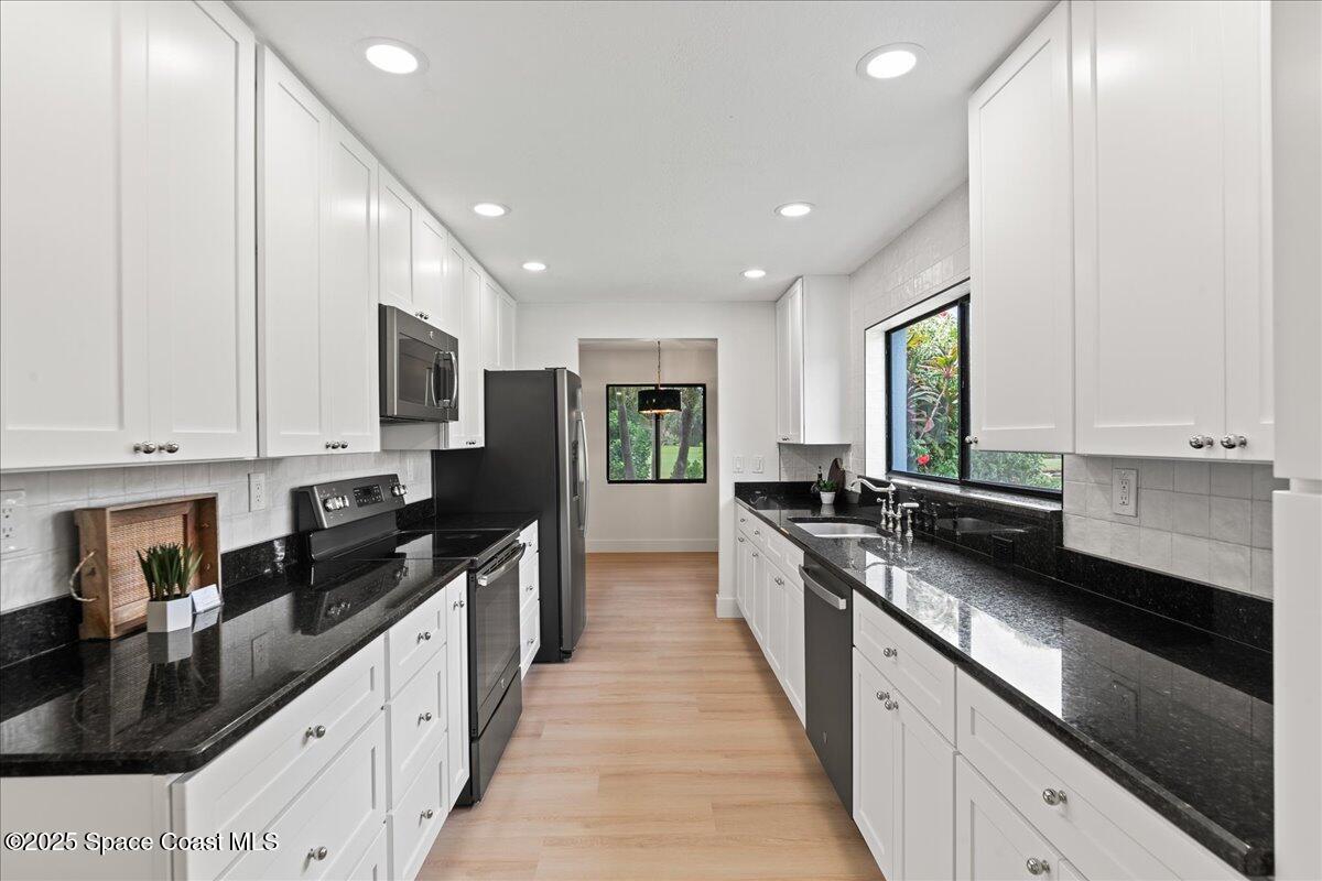 720 Wing Foot Lane Melbourne, FL 32940 - Photo 6 of 45 a large kitchen with stainless steel appliances granite countertop a sink a stove and a refrigerator