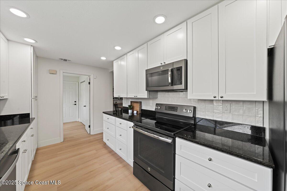 720 Wing Foot Lane Melbourne, FL 32940 - Photo 7 of 45 a kitchen with stainless steel appliances granite countertop a stove a sink and a microwave