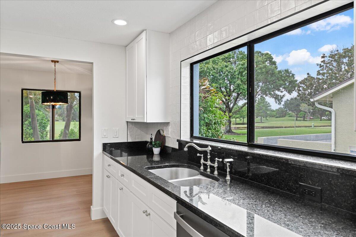 720 Wing Foot Lane Melbourne, FL 32940 - Photo 8 of 45 a kitchen with granite countertop a large window and a sink