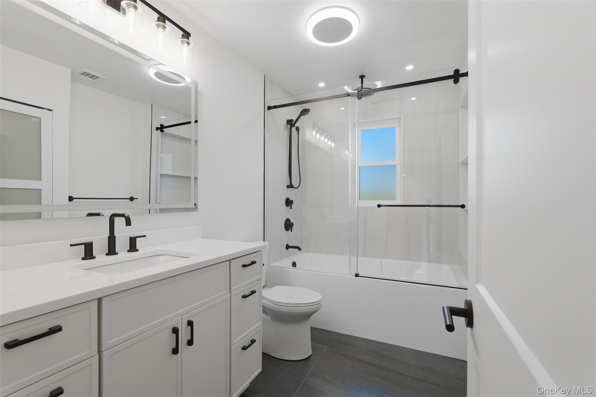 40 Calhoun Avenue New Rochelle, NY 10801 - Photo 19 of 49 Modern bathroom featuring a single vanity with a white countertop and matte black fixtures