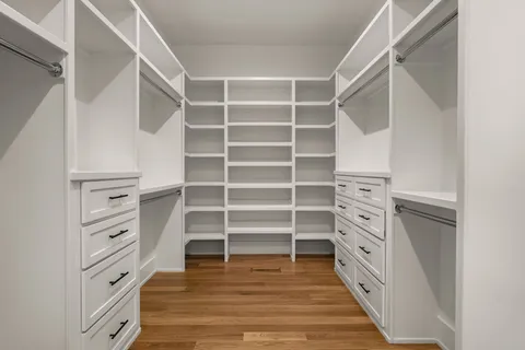 a view of walk in closet with empty racks
