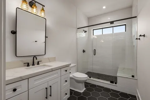 a bathroom with a double vanity sink mirror and toilet