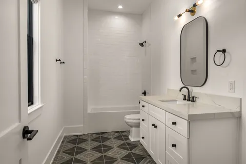a bathroom with a double vanity sink toilet and shower