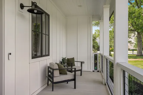 a view of a hallway with furniture and a window