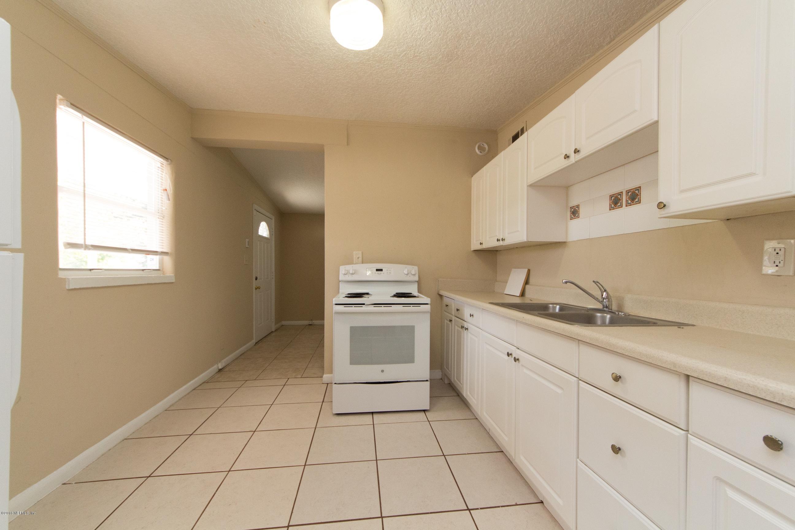 1702 Cortez Road Jacksonville, FL 32246 - Photo 9 of 24 a kitchen with a sink a stove cabinets and a window
