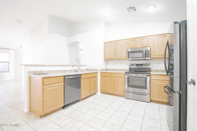 a kitchen with a refrigerator sink and cabinets