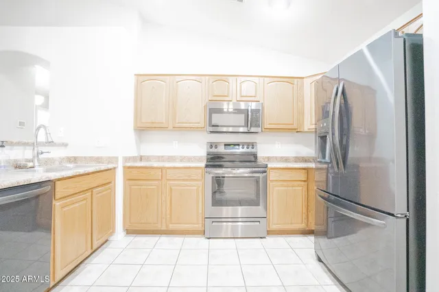 an empty room with a chandelier fan and windows