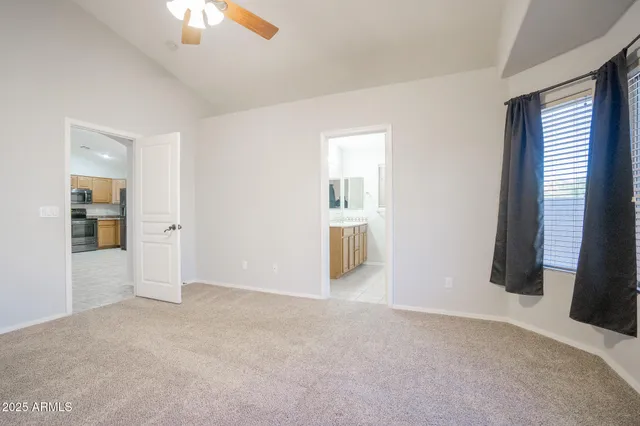 an empty room with a fan & a ceiling fan