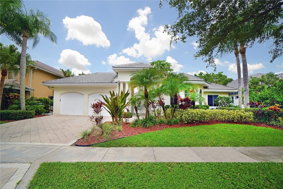 6039 Northwest 32nd Avenue Boca Raton, FL 33496 - Photo 1 of 18 a front view of a house with a yard and potted plants