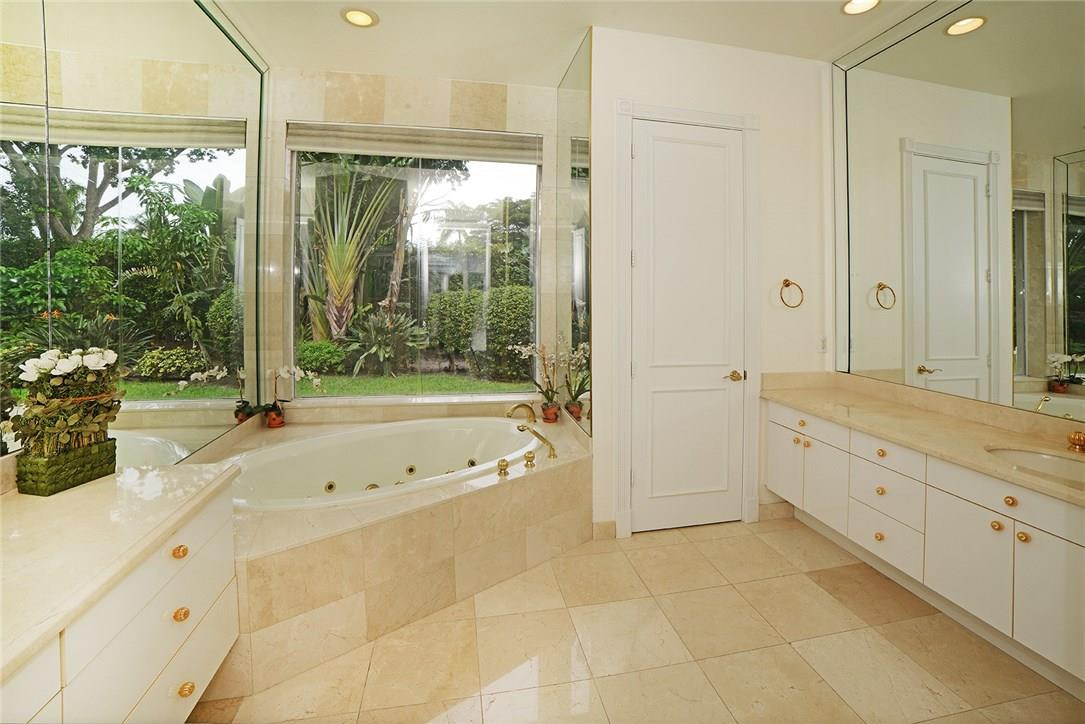 6039 Northwest 32nd Avenue Boca Raton, FL 33496 - Photo 16 of 18 a spacious bathroom with a tub sink and mirror