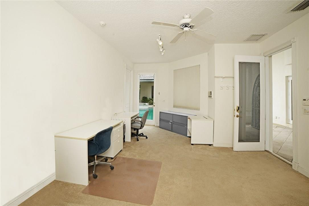 6039 Northwest 32nd Avenue Boca Raton, FL 33496 - Photo 17 of 18 a view of a workspace with furniture and a ceiling fan