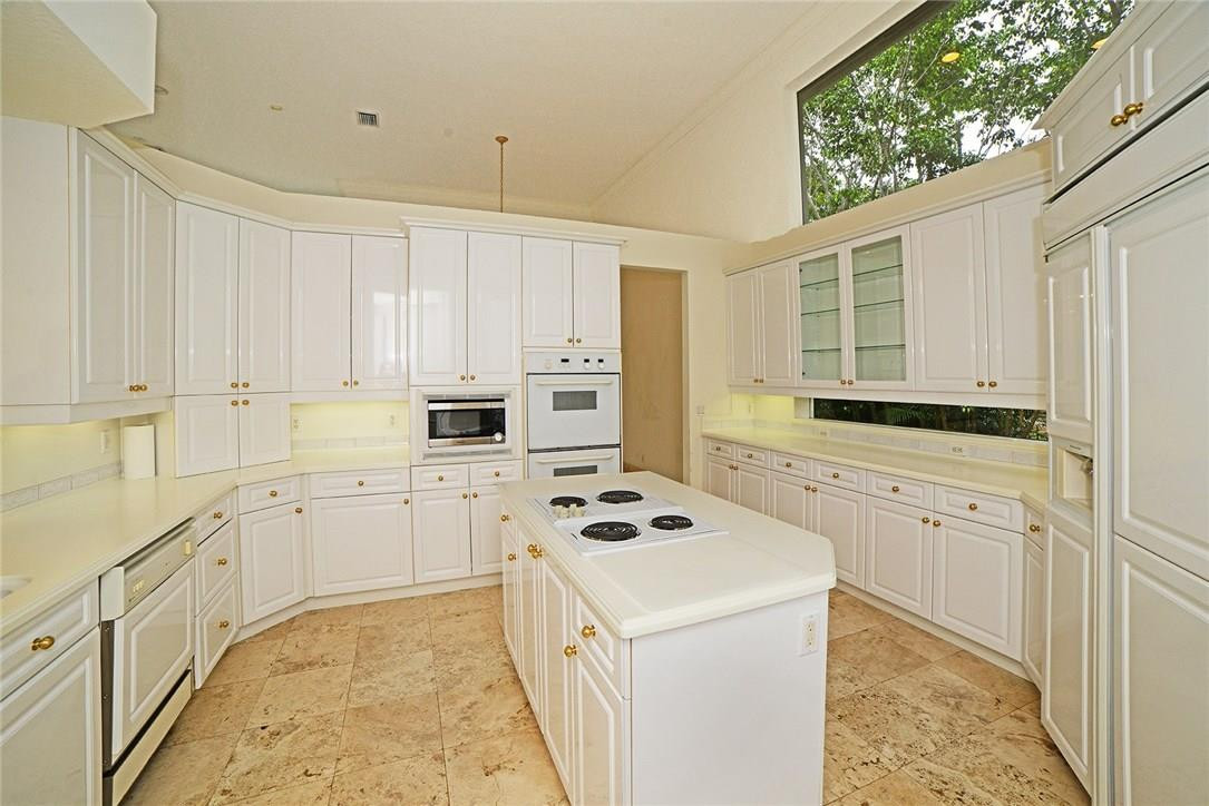 6039 Northwest 32nd Avenue Boca Raton, FL 33496 - Photo 8 of 18 a kitchen with white cabinets and white appliances